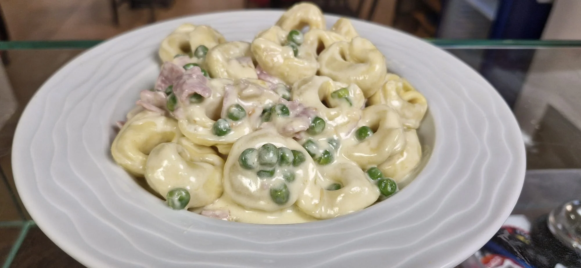 Tortellini con panna, prosciutto e piselli